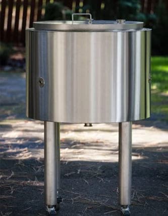 Round stainless steel tank with a lift-off lid standing on welded legs with casters