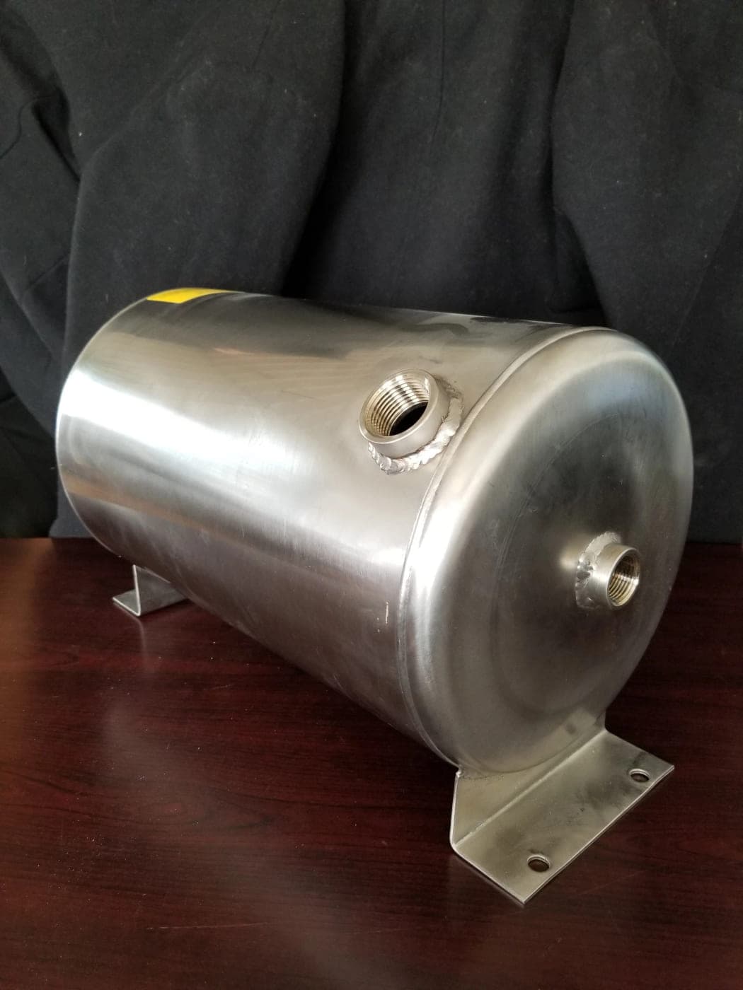 Small horizontal stainless steel pressure tank with threaded ports and welded mounting feet