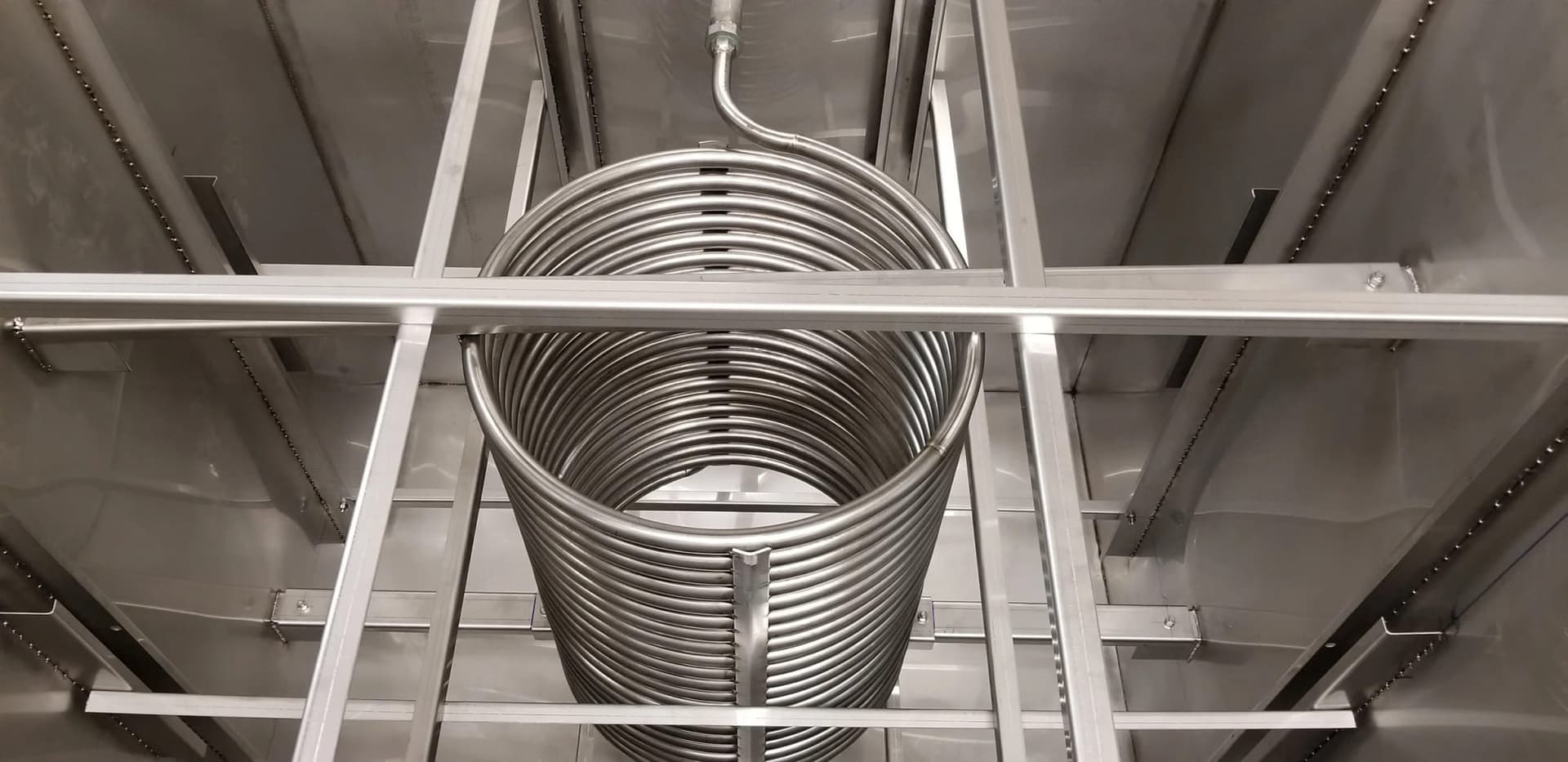 Stainless steel heat exchange coil inside a fabricated tank