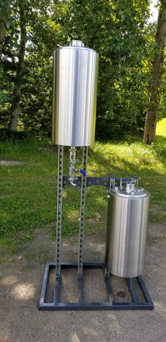 Two-vessel stainless steel assembly mounted on a fabricated steel stand